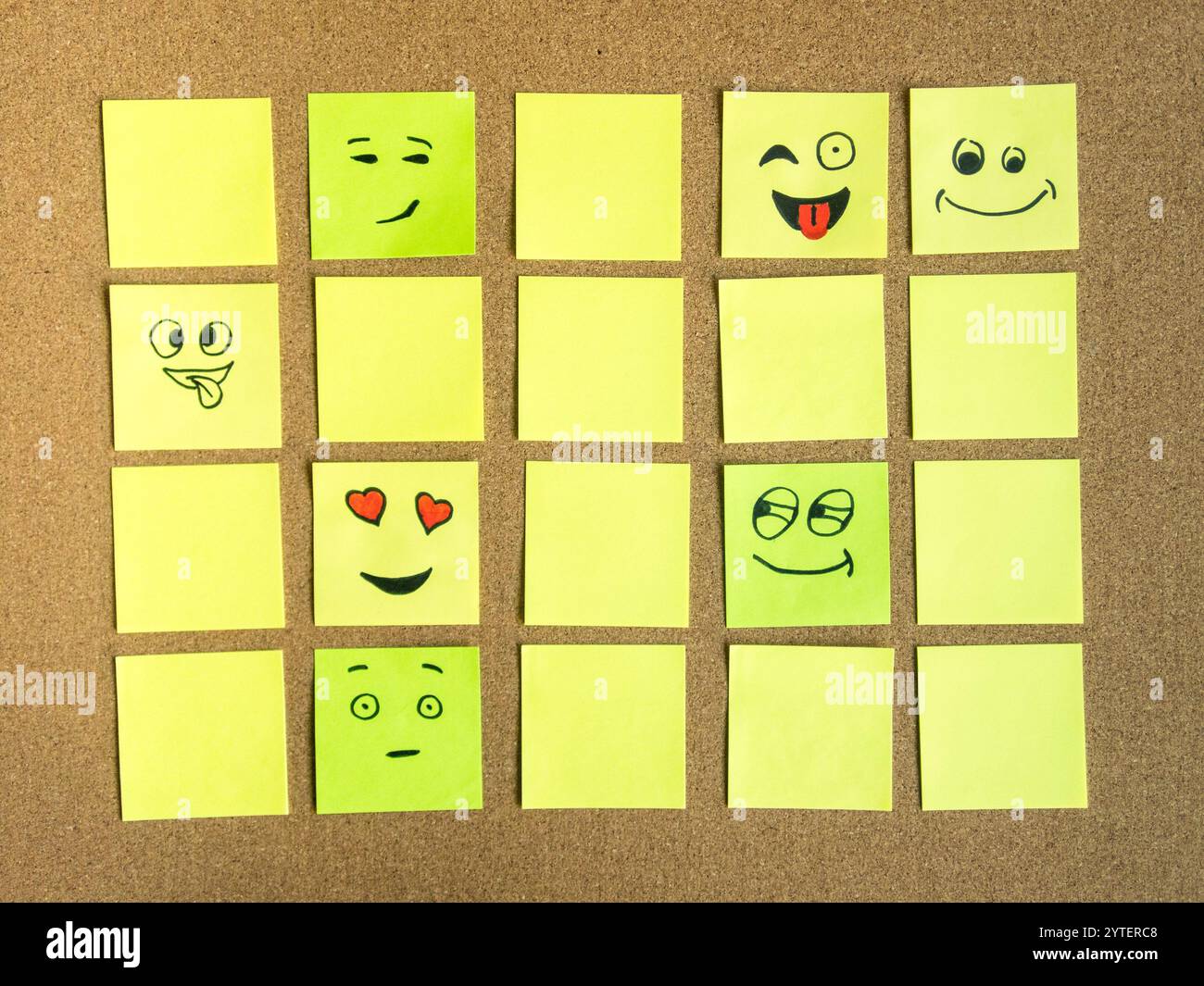 appunti autoadesivi per l'ufficio con diversa espressione del volto sul bordo in sughero come foto astratta Foto Stock