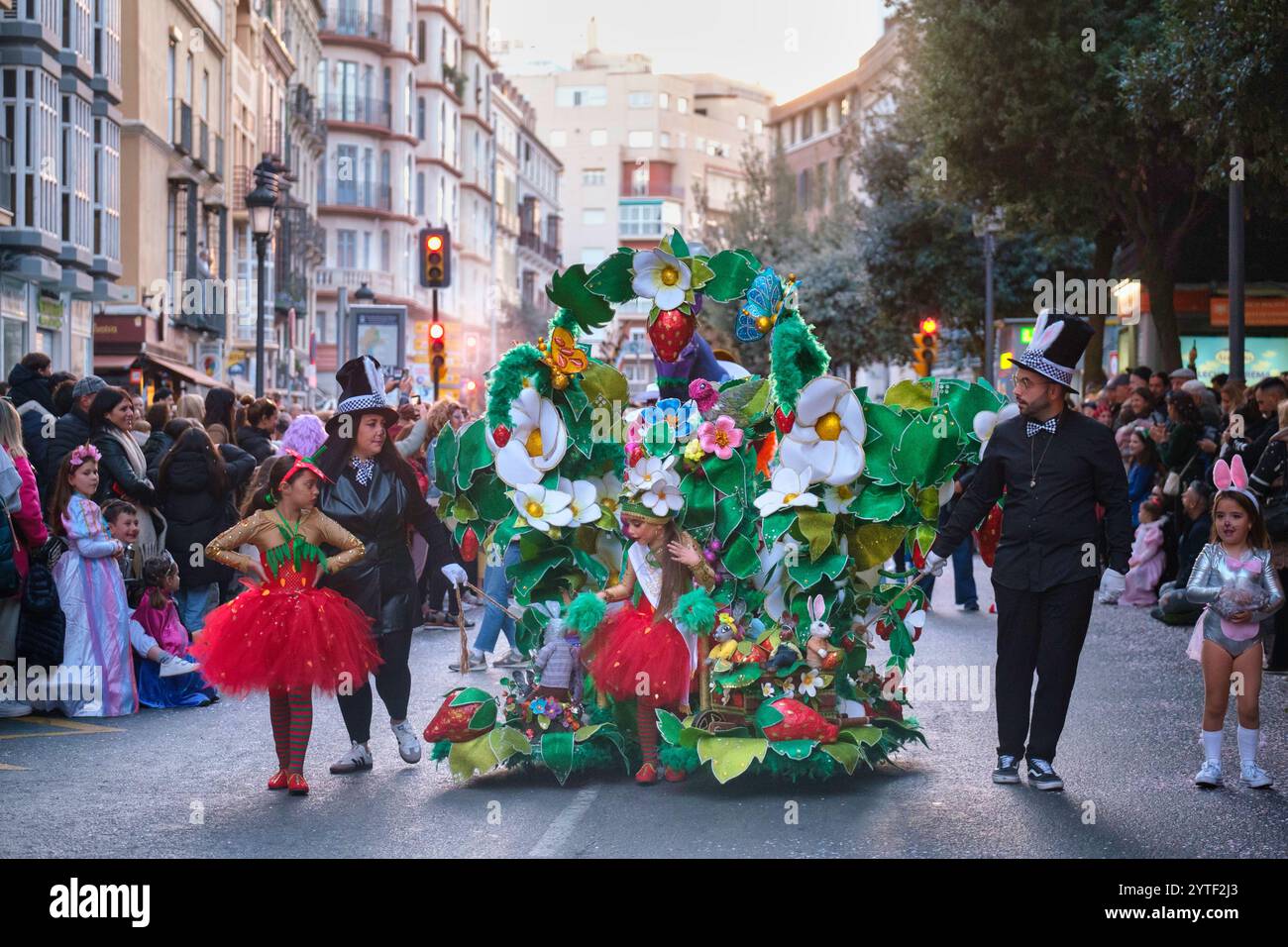 L'immagine raffigura una scena di strada festosa, probabilmente durante una sfilata o una celebrazione. Una persona è vestita con un costume grande ed elaborato che assomiglia a Foto Stock