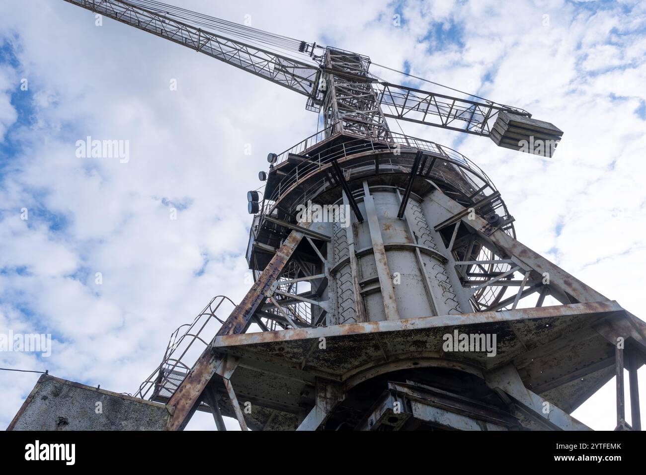 Gru industriale contro un cielo nuvoloso in un sito di estrazione dello zolfo abbandonato. Foto Stock