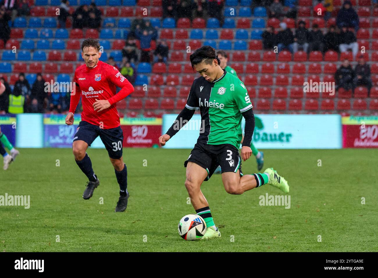 Hayate Matsuda (Hannover 96 II, #03) mit Ball mit Simon Skarlatidis (SpVgg Unterhaching, 30), GER, SpVgg Unterhaching vs. Hannover 96 II, Fussball, 3. Liga, 17 anni. Spieltag, Saison 2024/2025, 07.12.2024, LE NORMATIVE DFL VIETANO QUALSIASI USO DI FOTOGRAFIE COME SEQUENZE DI IMMAGINI, foto: Eibner-Pressefoto/Jenni Maul Foto Stock