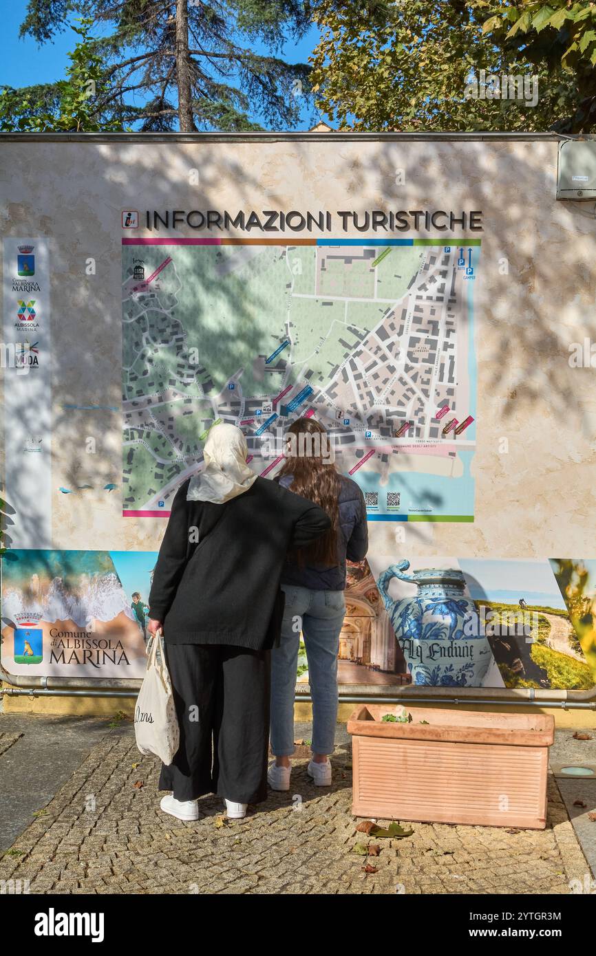 Savona. Italia - 07 dicembre 2024: Due persone che guardano una cartina presso un punto di informazione turistica di Albissola Marina, Savona, Italia. Perfetto per lo spettacolo Foto Stock