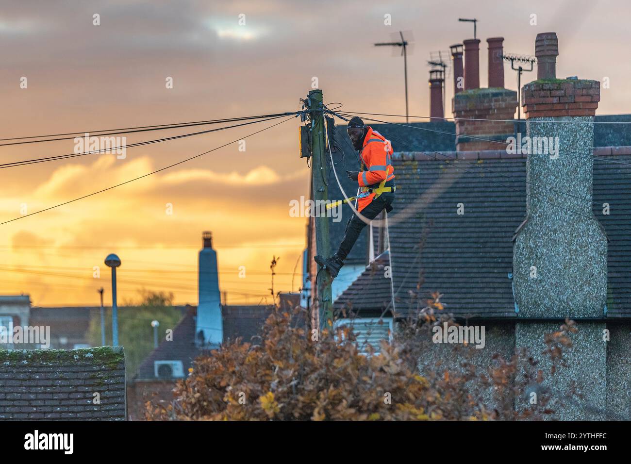 BT Engineer su un palo telefonico sulla banda larga in fibra ottica Garrick Rd nel tardo pomeriggio, Northampton, Inghilterra, Regno Unito. Foto Stock