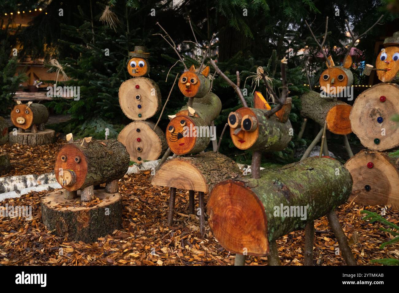 Le colorate figure in legno creano una stravagante esposizione natalizia in un accogliente giardino, esaltando lo spirito festivo Foto Stock