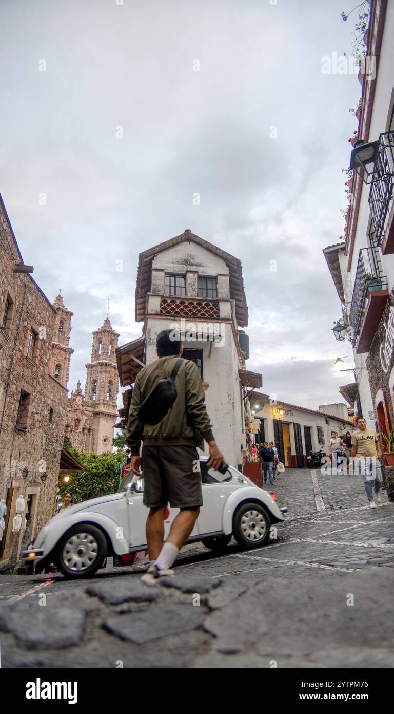 Nell'affascinante città di Taxco de Alarcon, una persona passeggia lungo una strada acciottolata, circondata da edifici storici e da una cultura vivace. Foto Stock