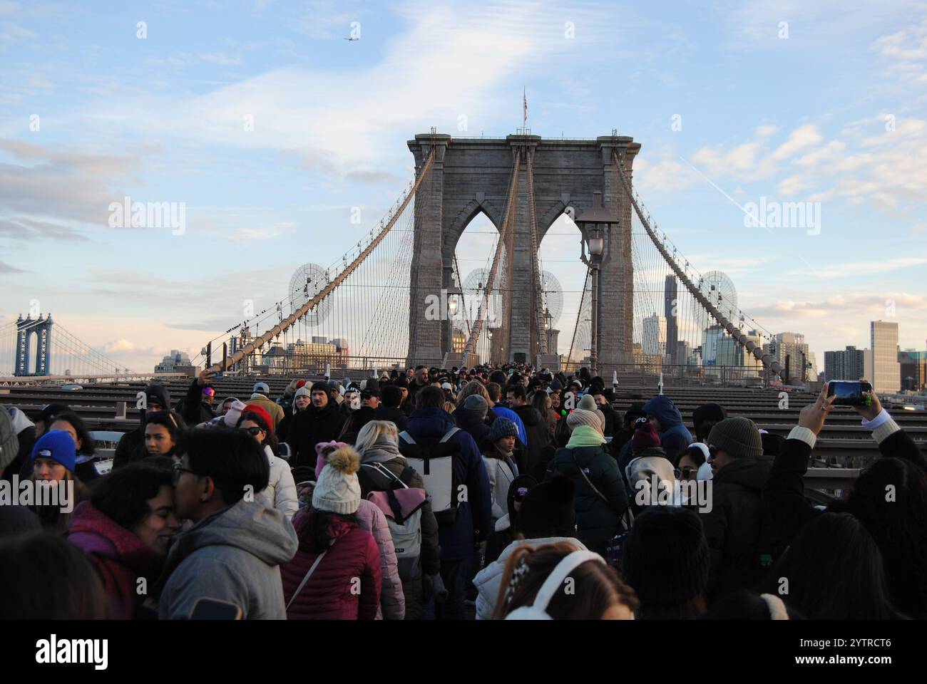 New York City, New York, USA - 7 dicembre 2024: Il ponte di Brooklyn è un'attrazione molto popolare con folle di persone che attraversano Manhattan e Brooklyn. Foto Stock