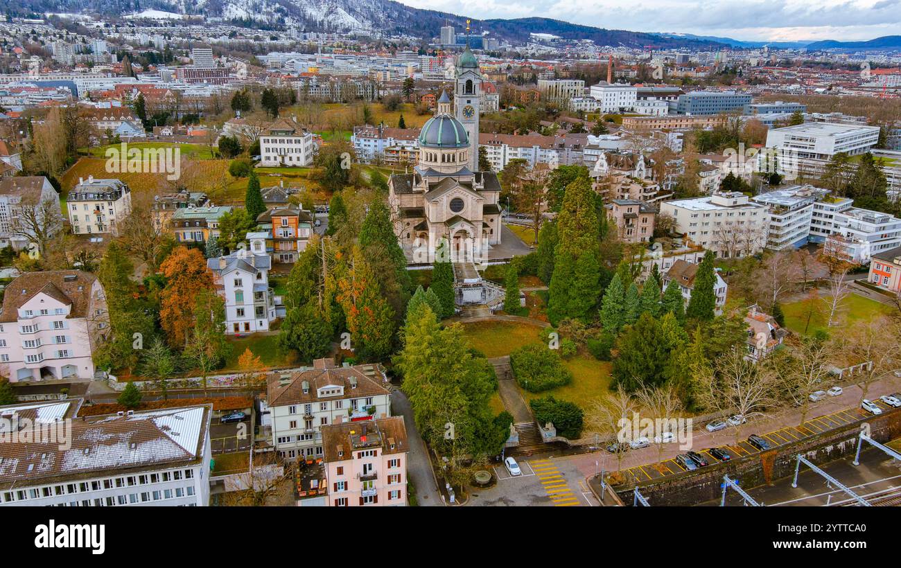 Splendida vista aerea della chiesa storica circondata da vegetazione lussureggiante e dall'affascinante architettura di Zurigo, Svizzera. Un'istantanea perfetta della tradizione svizzera Foto Stock