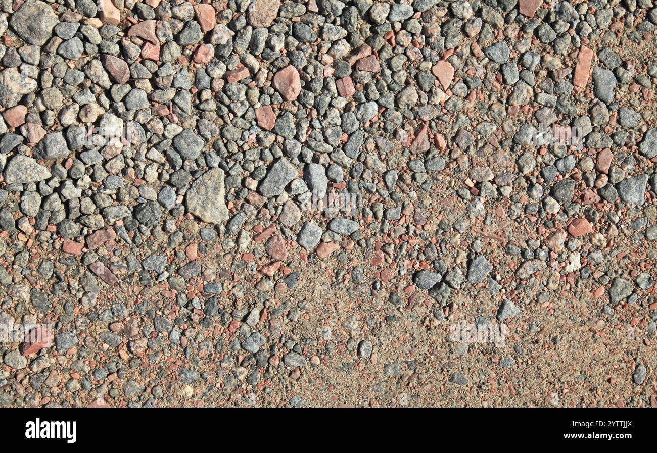 Superficie in pietra, sfondo. Trama dettagliata della strada cosparsa di pietre di granito. Sfondo caotico in pietra. Fondazioni stradali con pietre Foto Stock
