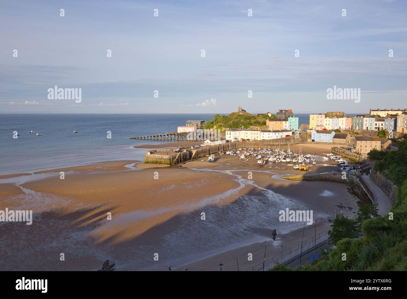 Con la bassa marea, le barche nel porto di Tenby sono su terreno asciutto. Foto Stock