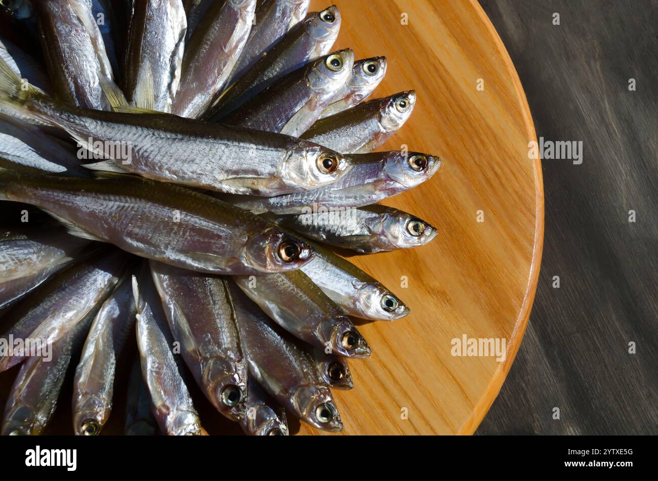 I pesci secchi sanguinano su una tavola di legno. Pesce grasso molto gustoso per la birra. Foto Stock