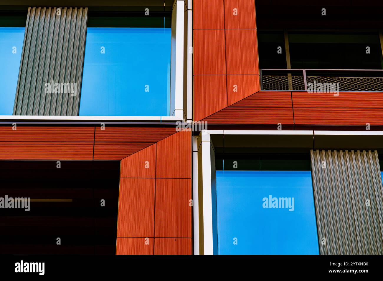 Edificio moderno con pannelli rossi e bianchi e finestre riflettenti in vetro Foto Stock