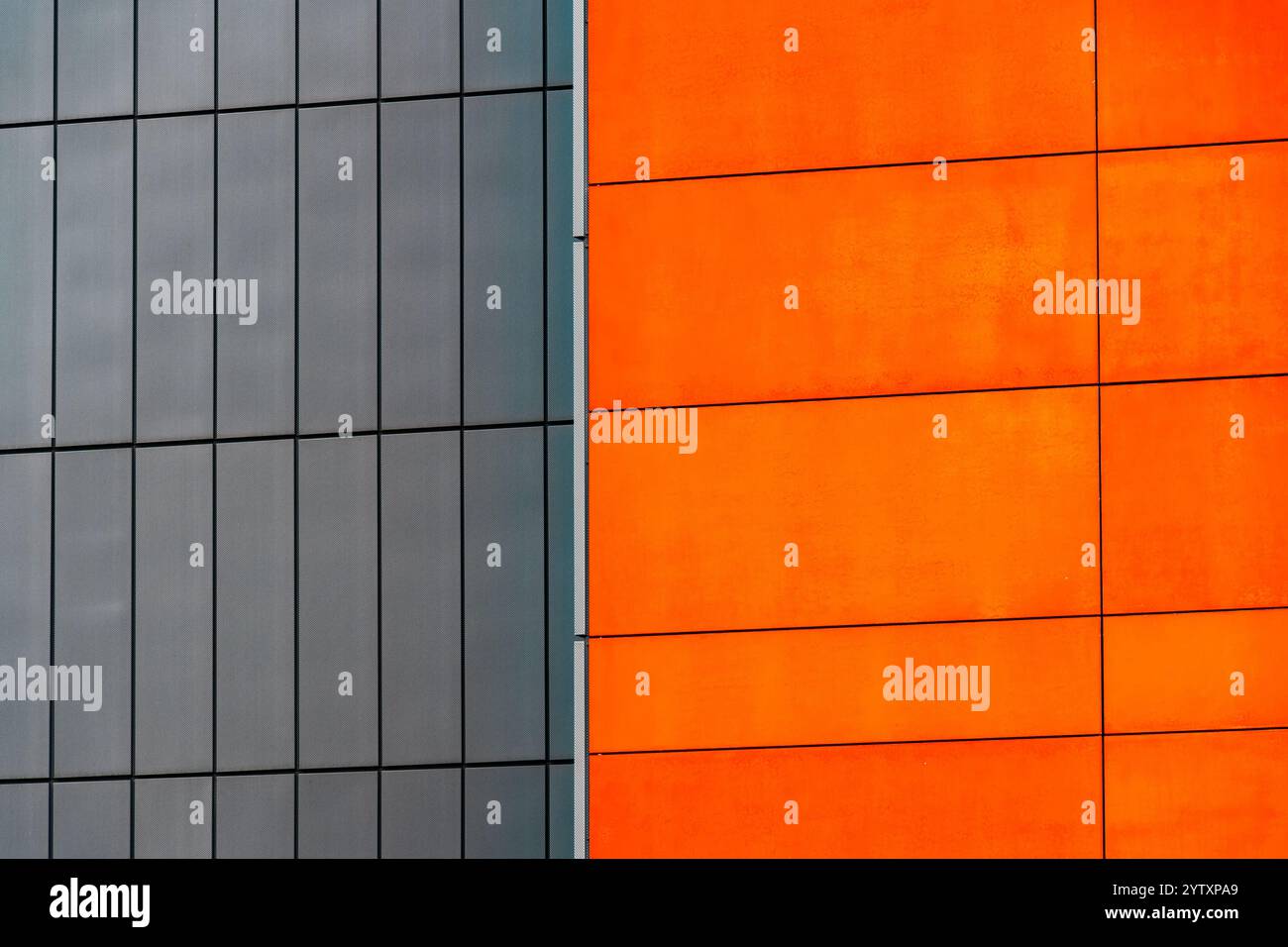 Edificio moderno con pannelli in grassetto arancione e pareti in metallo grigio a contrasto Foto Stock