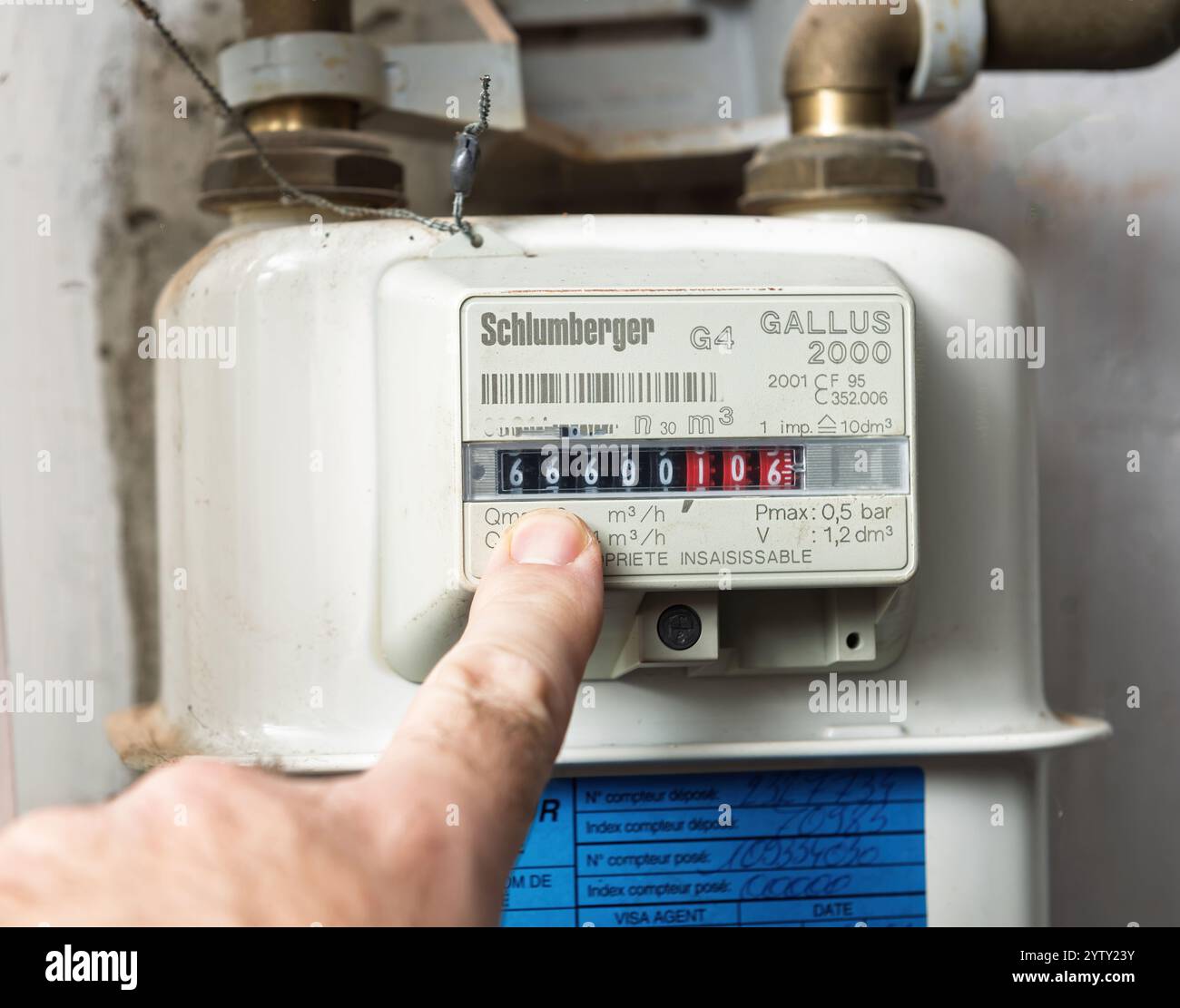 Parigi, Francia- 22 novembre 2021: Primo piano di un contatore di gas Schlumberger che mostra la lettura 666 con un dito che punta al contatore e il numero è un numero satanico, montato su una parete Foto Stock