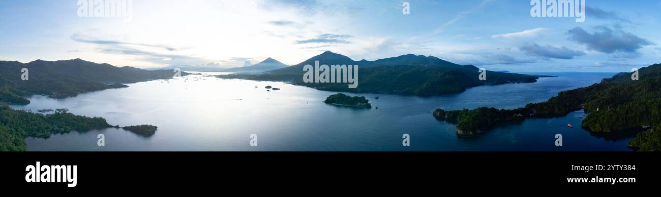Il sole tramonta sullo stretto di Lembeh, separando Sulawesi settentrionale dall'isola di Lembeh. Quest'area tropicale ospita una pletora di biodiversità marina. Foto Stock