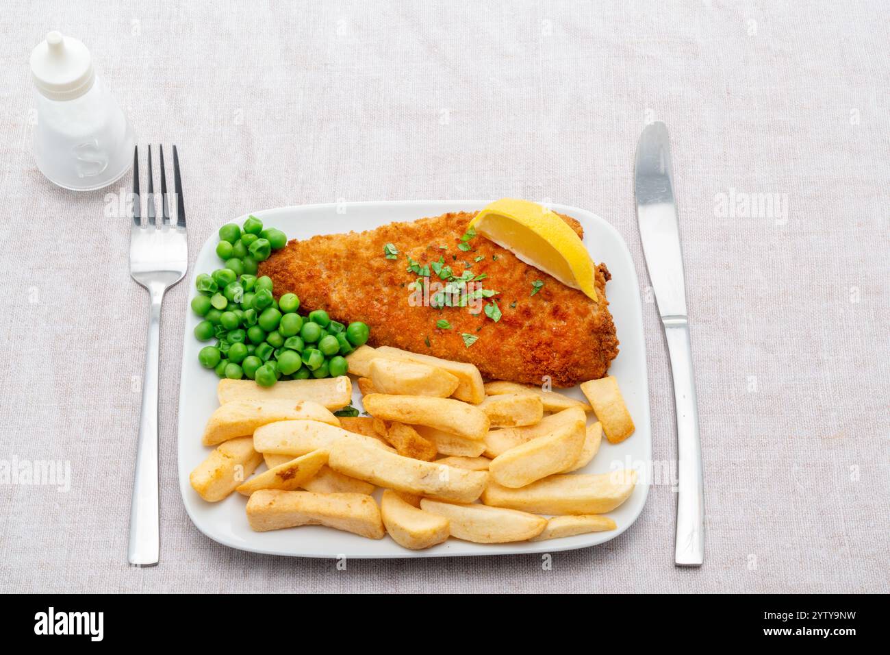 Una porzione di fish and chips con piselli Foto Stock