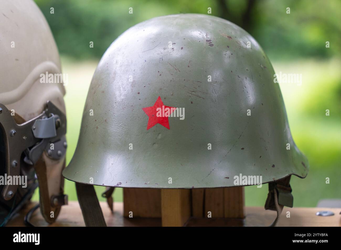 Vecchio casco militare verde con emblema comunista della stella rossa Foto Stock