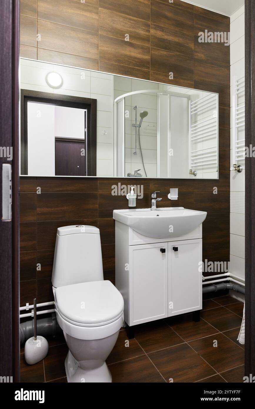 Scoprite il moderno design del bagno con finiture eleganti e caldi accenti in legno per l'eleganza Foto Stock