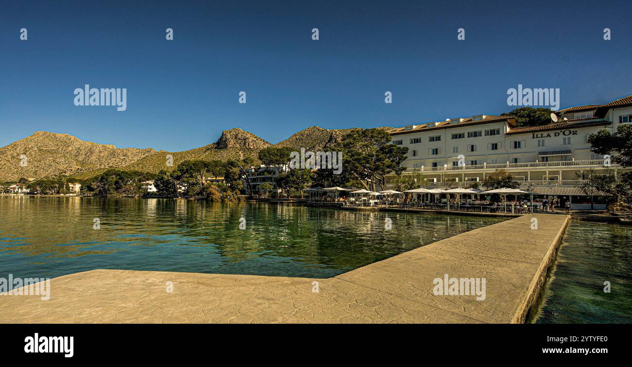 Blick vom Bootssteg auf das Hotel Illa d'Or, den Pine Walk und das Tramuntana-Geibirge, Port de Pollenca, Maiorca, Spanien Foto Stock