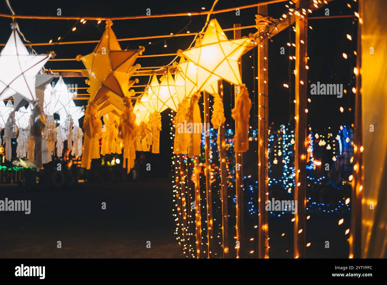Le lanterne a stella dorata o gialla e bianca appese come decorazione del parco durante le festività natalizie e la stagione delle yuletide Foto Stock Le lanterne a stella dorata o gialla e bianca appese come decorazione del parco durante le festività natalizie e la stagione delle yuletide Foto Stock