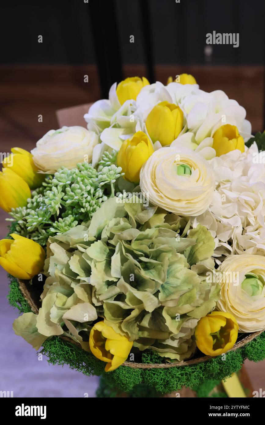 Una splendida e splendida disposizione floreale con accenti giallo brillante e verde Foto Stock