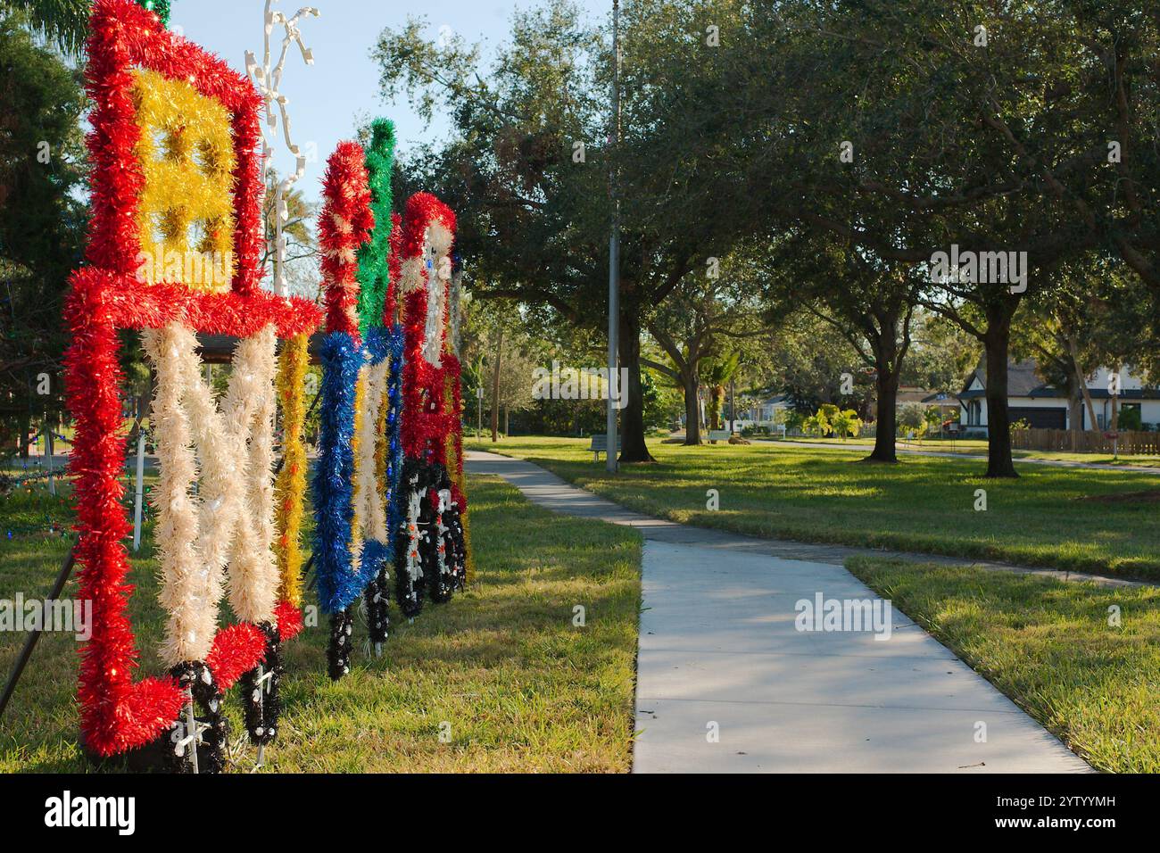 Uso editoriale solo il 7 dicembre 2024. Gulfport, Florida, Stati Uniti. Decorazioni natalizie in linea sul marciapiede a Clymer Park nel tardo pomeriggio. Foto Stock