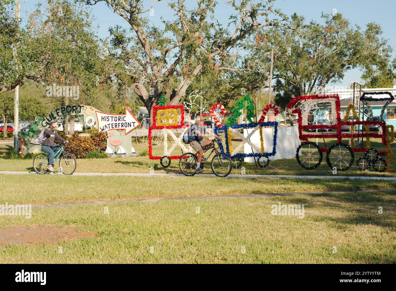 Uso editoriale solo il 7 dicembre 2024. Gulfport, Florida, Stati Uniti. Decorazioni natalizie per due persone in bicicletta e cartello con la freccia nel Clymer Park Late Foto Stock