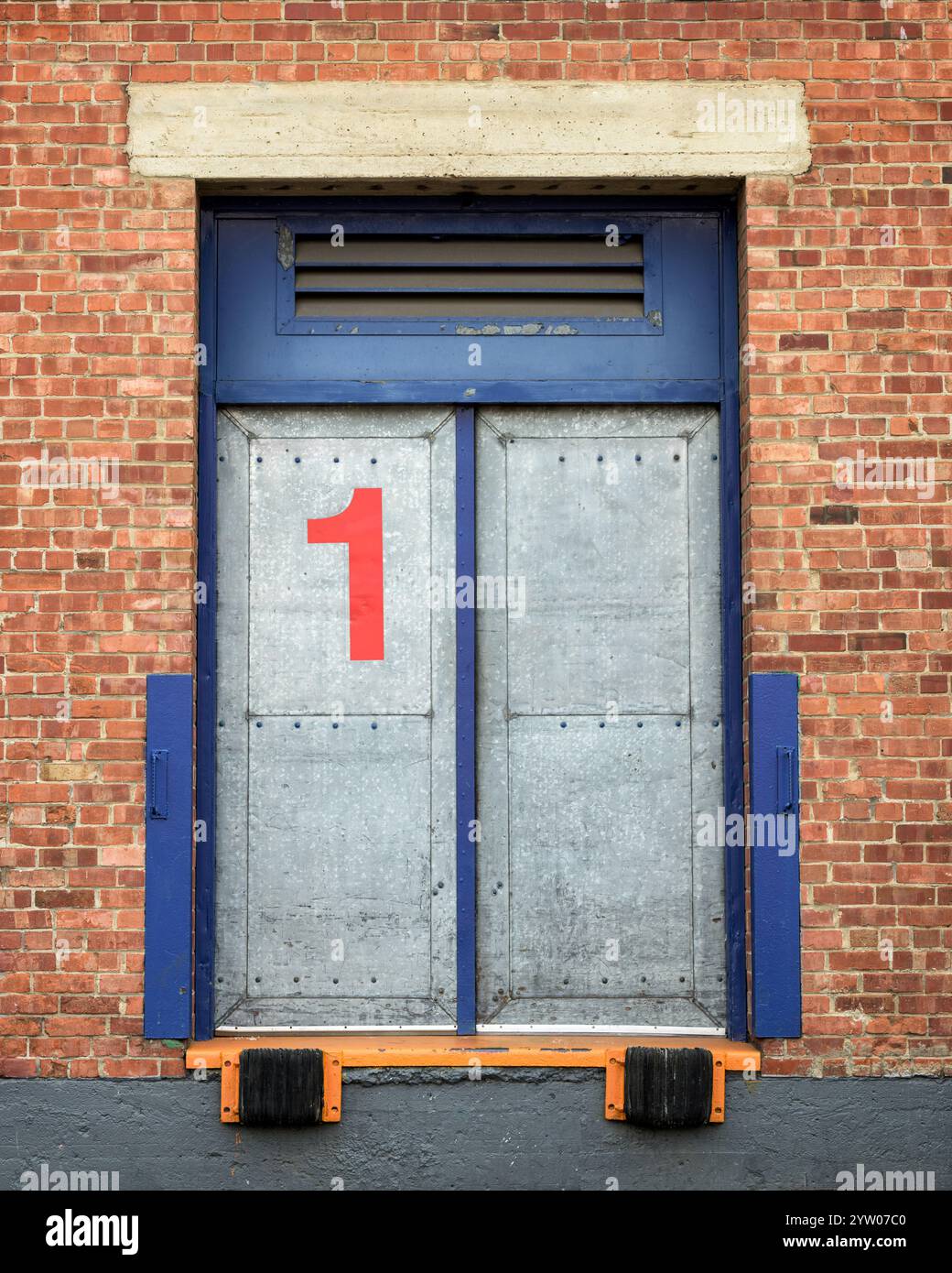 Semplice immagine della banchina di carico con il numero 1 in rosso circondato da un muro di mattoni Foto Stock