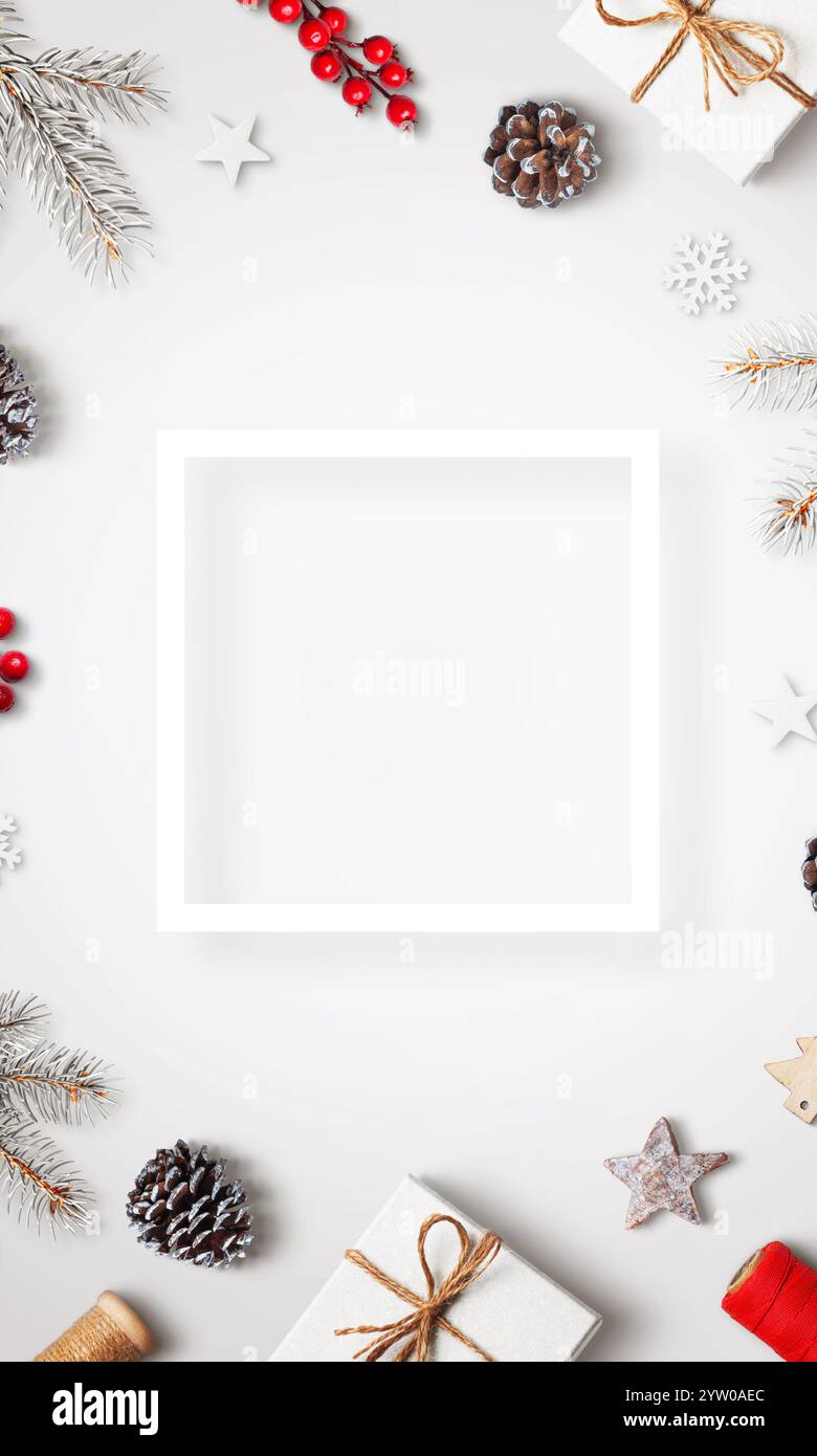 Tavolo bianco con decorazioni natalizie, vista dall'alto, disposizione piatta, con cornice bianca quadrata per testo o logo, che ricorda un bellissimo saluto natalizio c Foto Stock