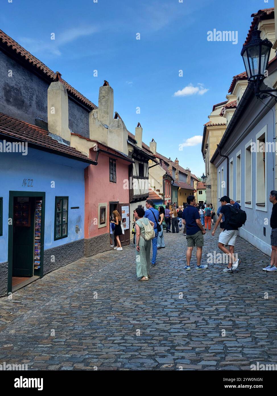 Turisti che passeggiano lungo Una pittoresca e affascinante strada acciottolata europea - Immagine stock catturata con smartphone