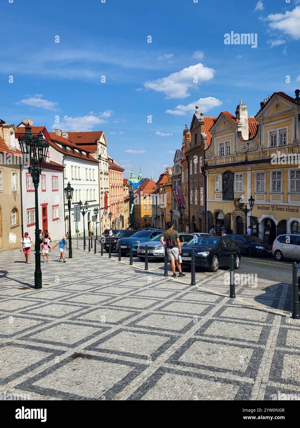 Affascinante strada di Praga con edifici storici sotto il cielo azzurro - Immagine stock catturata con smartphone