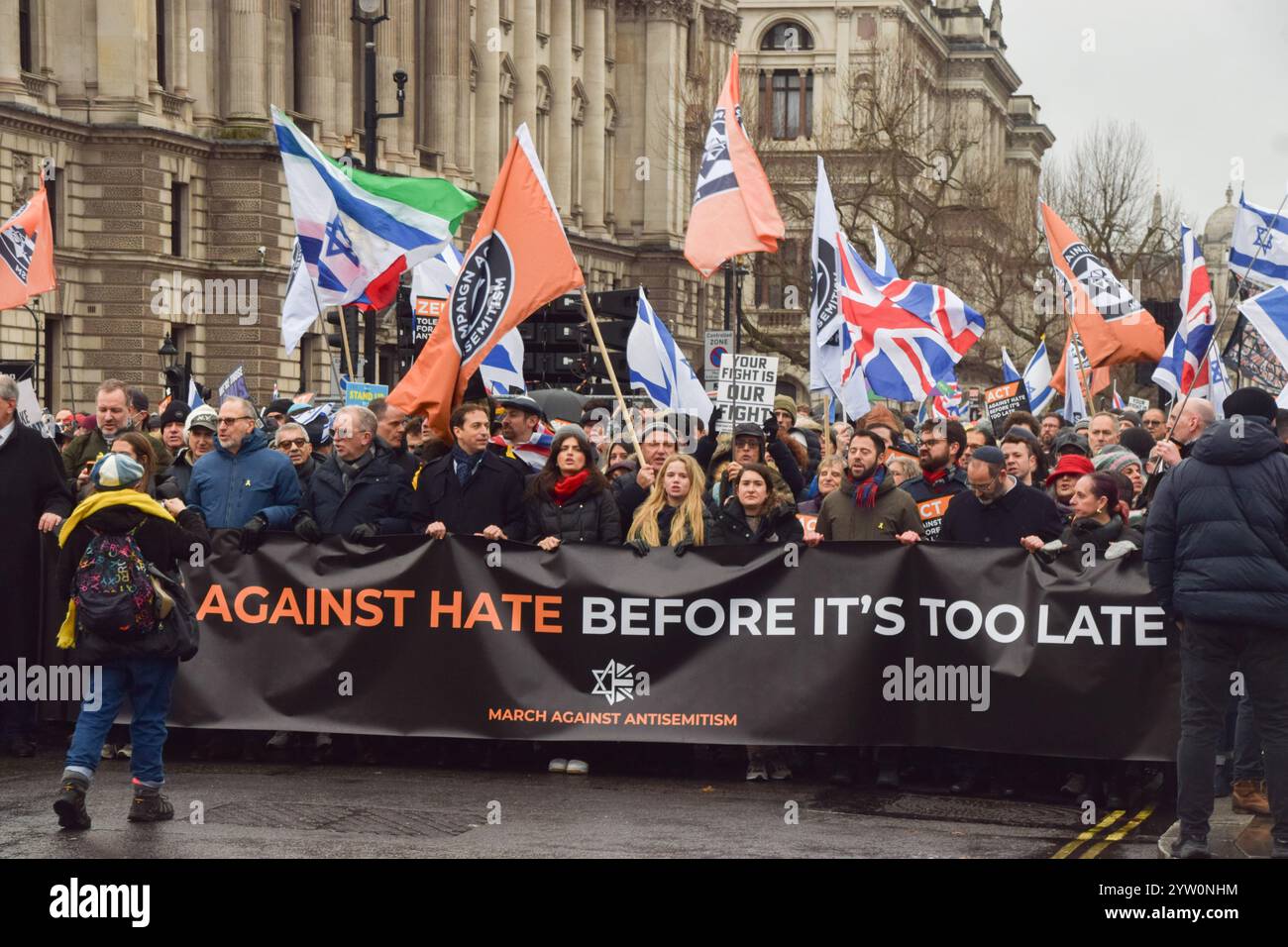 Londra, Regno Unito. 8 dicembre 2024. I manifestanti marciano con uno striscione che recita "agire contro l'odio prima che sia troppo tardi" durante la manifestazione a Whitehall. Migliaia di persone hanno marciato nel centro di Londra contro l'antisemitismo e a sostegno di Israele mentre Israele continua i suoi attacchi a Gaza. Credito: SOPA Images Limited/Alamy Live News Foto Stock