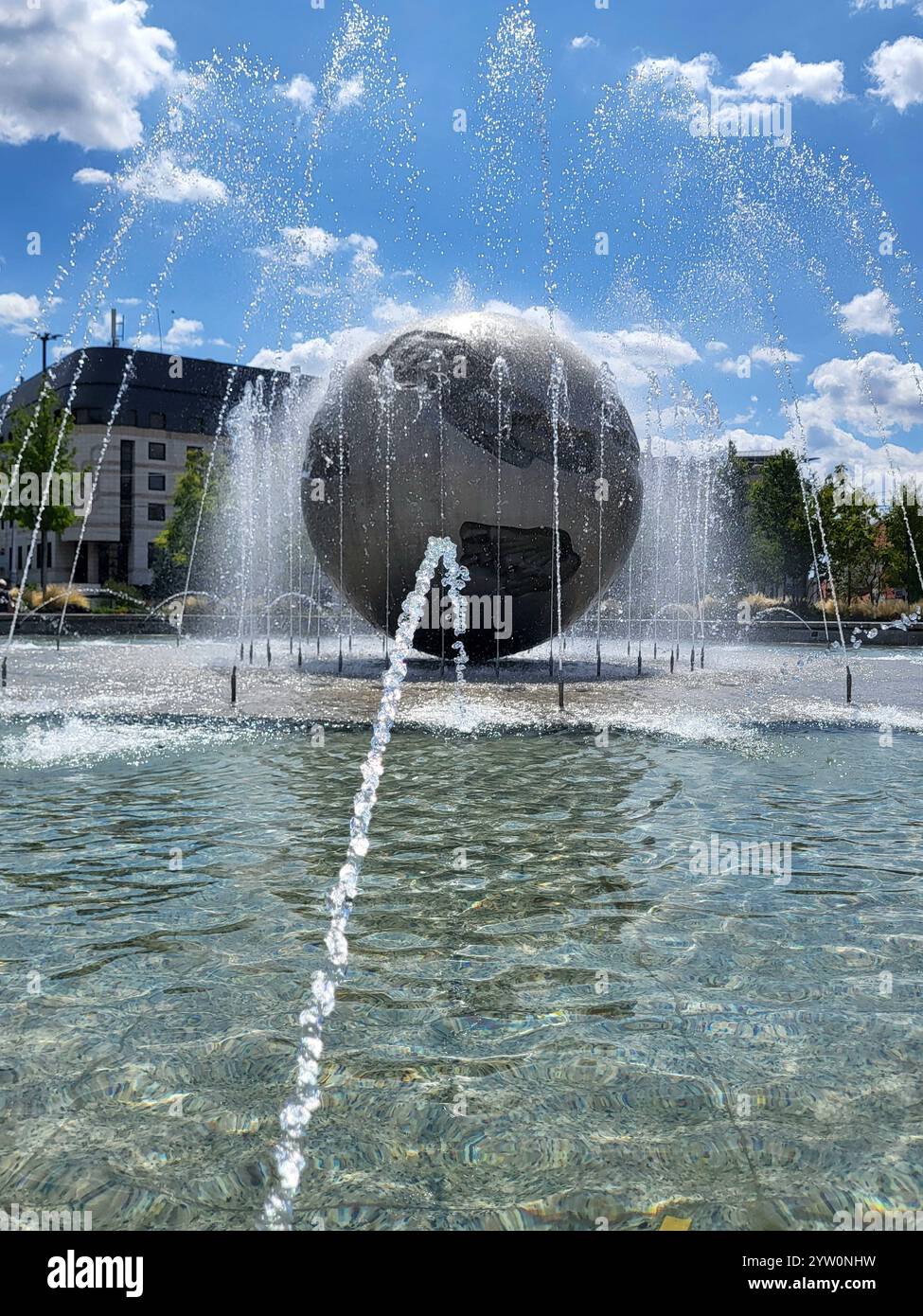 Fontana maestosa con struttura Globe nell'ambiente del Parco Urbano il giorno della domenica - Immagine stock catturata con smartphone