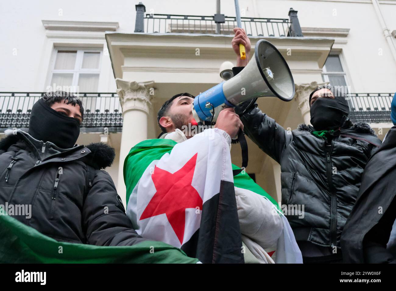 Londra, Regno Unito. 8 dicembre 2024. I britannici-siriani si sono riuniti per celebrare la fine del regime di Assad in Trafalgar Square, dove in seguito un grande gruppo ha marciato verso l'ambasciata siriana, chiedendo che la bandiera del precedente governo fosse abbattuta dall'edificio e sostituita con le tre forze di opposizione con la bandiera rossa. Credito: Fotografia dell'undicesima ora/Alamy Live News Foto Stock