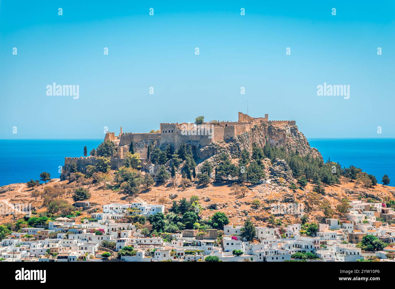 Il villaggio di Lindos con case bianche e l'iconica Acropoli in cima alla collina. A Rhodos Island, Dodecaneso, Grecia. Foto Stock