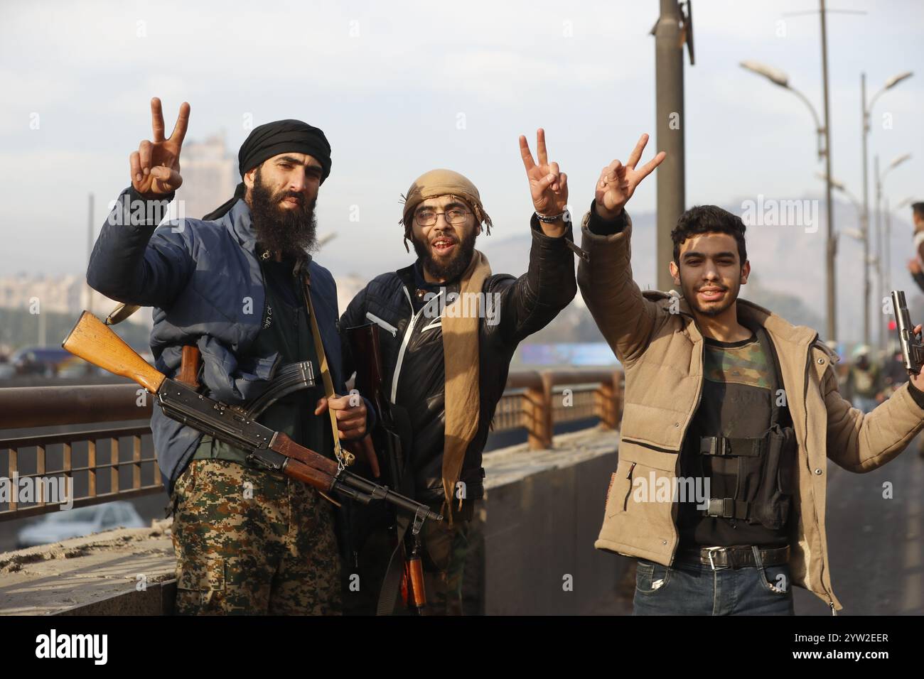 Damasco. 8 dicembre 2024. Questa foto scattata l'8 dicembre 2024 mostra i combattenti dei ribelli a Damasco, in Siria. Le forze dell'opposizione armata siriana hanno preso il pieno controllo di Damasco domenica, ponendo fine a oltre cinquant'anni di governo della famiglia Assad. Il ministero degli Esteri russo ha rilasciato una dichiarazione in cui si afferma che il presidente siriano Bashar al-Assad "ha deciso di lasciare il posto presidenziale e ha lasciato il paese, dando istruzioni per trasferire il potere in pace". Crediti: Str/Xinhua/Alamy Live News Foto Stock