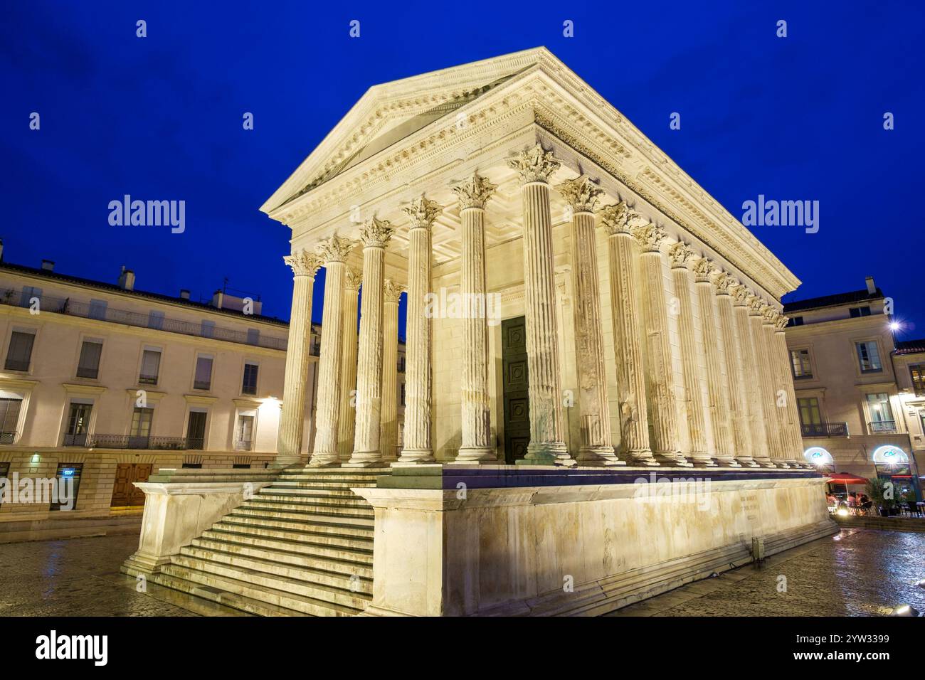 Maison CarrÃ©e antico tempio romano su Place de la Maison CarrÃ©e di notte Foto Stock