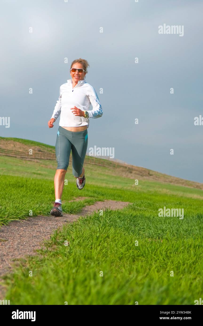 Una donna si allena per una maratona, per una corsa su pista al lago artificiale di Boulder. Boulder, CO Foto Stock