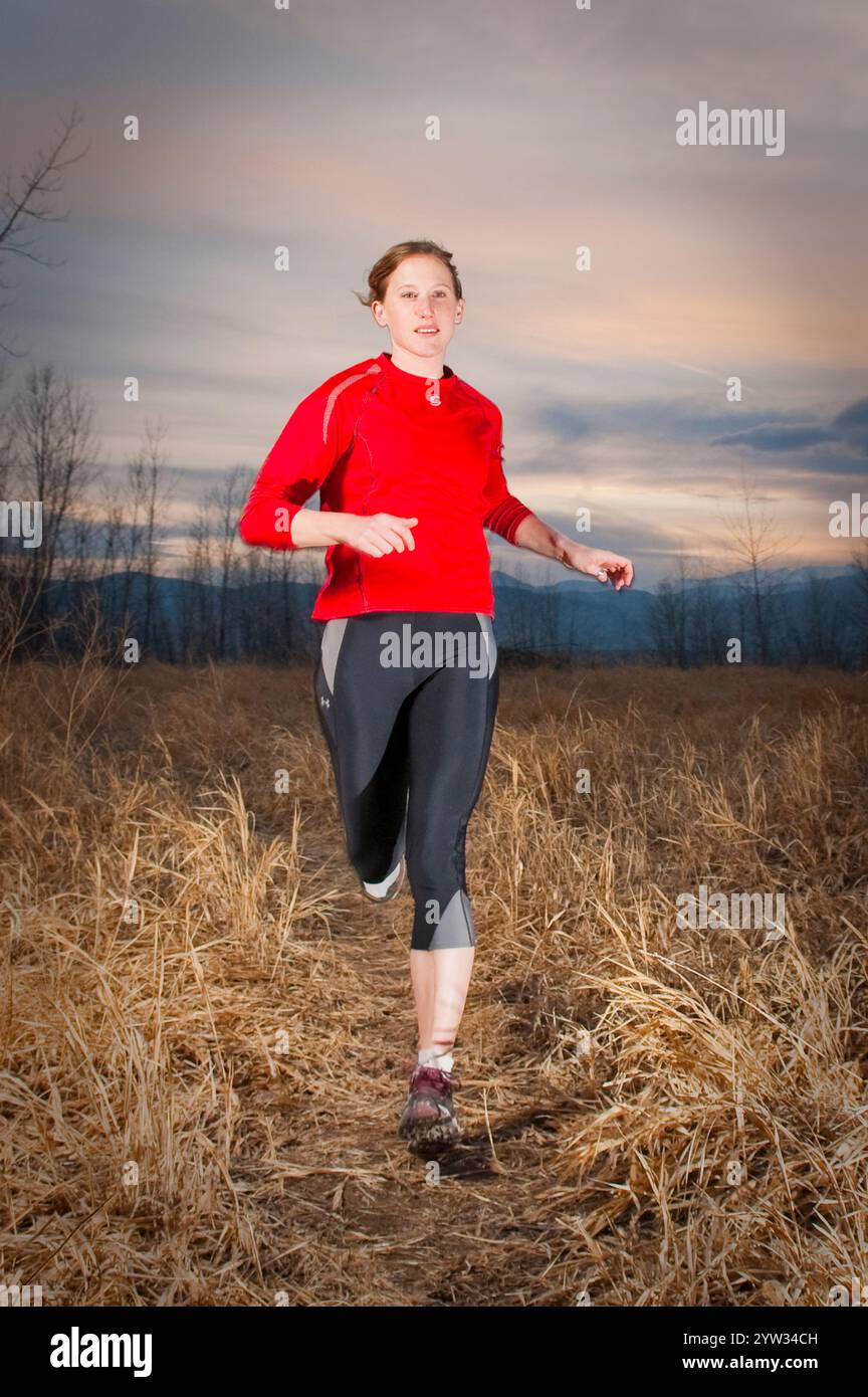 Un sentiero per giovani donne corre al crepuscolo al lago artificiale di Boulder. Boulder, CO. (Riempimento-flash) Foto Stock