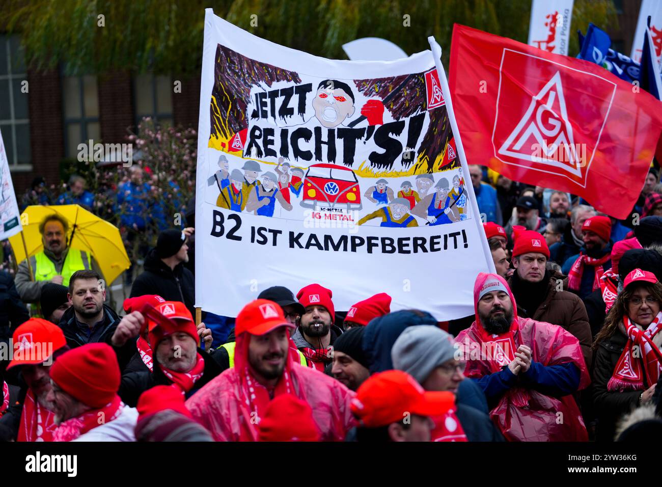 Wolfsburg, Germania. 9 dicembre 2024. I dipendenti VW partecipano a un rally IG Metall di fronte alla sede centrale della Volkswagen durante uno sciopero di allerta nello stabilimento principale del produttore automobilistico tedesco di Wolfsburg. Lo striscione recita: "Basta! - B2 è pronto a combattere! Credito: Martin Meissner/AP POOL/dpa/Alamy Live News Foto Stock