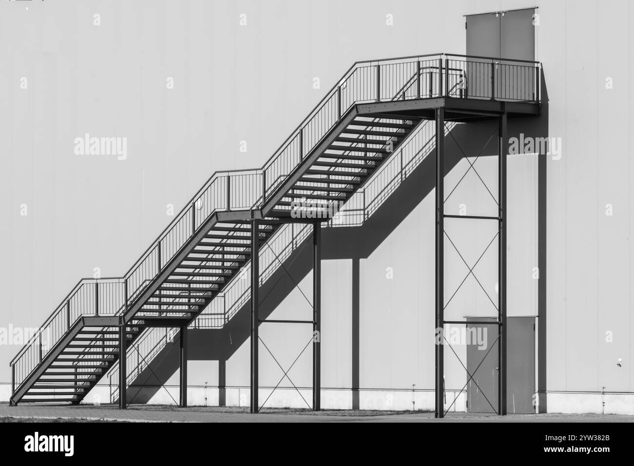 Scala di grigi per raggiungere l'edificio al sole Foto Stock