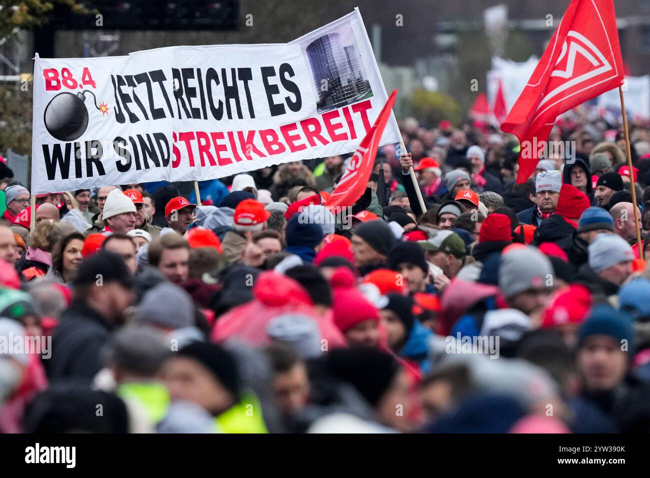 Wolfsburg, Germania. 9 dicembre 2024. I dipendenti VW partecipano a un rally IG Metall di fronte alla sede centrale della Volkswagen durante uno sciopero di allerta nello stabilimento principale del produttore automobilistico tedesco di Wolfsburg. Lo striscione recita: "Basta, siamo pronti a colpire”. Credito: Martin Meissner/AP POOL/dpa/Alamy Live News Foto Stock