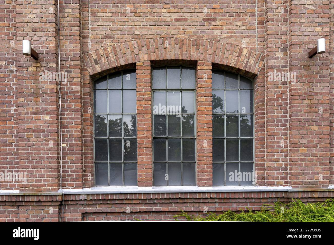 Finestre di un edificio industriale in mattoni risalente a 100 anni fa Foto Stock