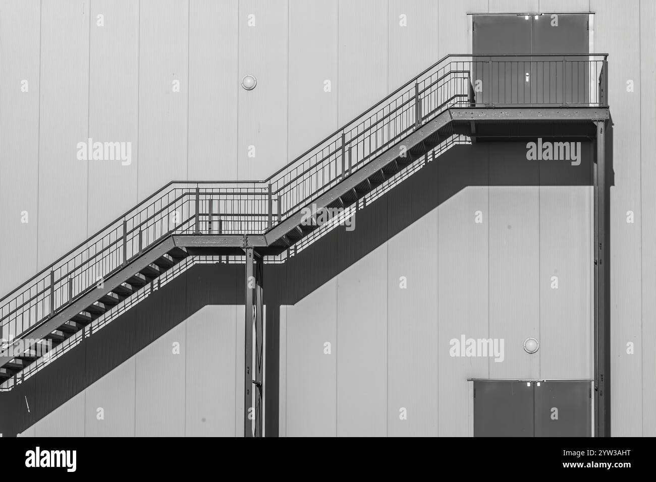 Scala di grigi per raggiungere l'edificio al sole Foto Stock