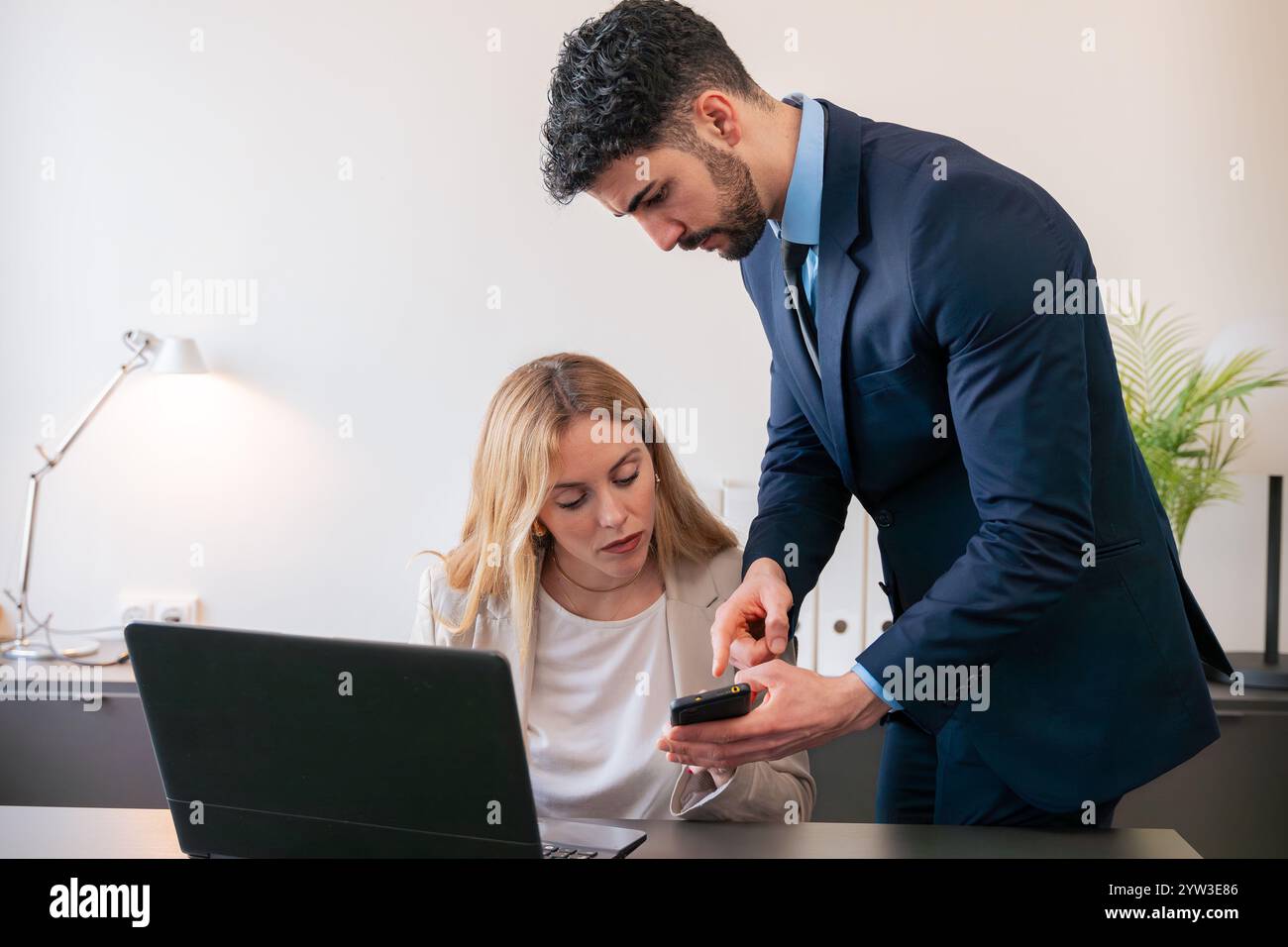 Colleghi di lavoro che collaborano con smartphone in Modern Office Foto Stock