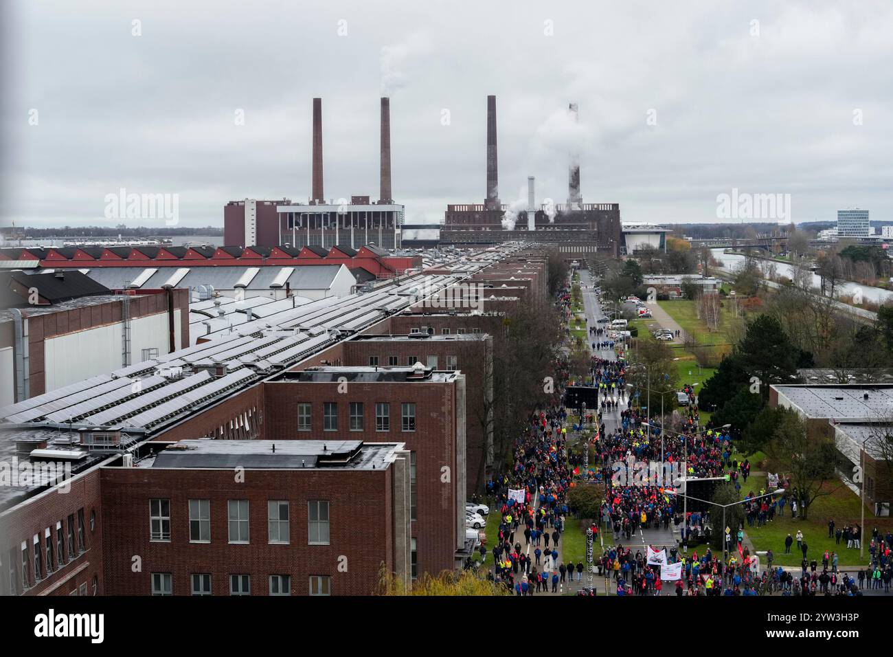 Wolfsburg, Germania. 9 dicembre 2024. I lavoratori VW partecipano a un raduno IG Metall fuori dalla sede centrale della Volkswagen durante uno sciopero di allerta nello stabilimento automobilistico tedesco di Wolfsburg, in Germania. Credito: Martin Meissner/AP POOL/dpa/Alamy Live News Foto Stock