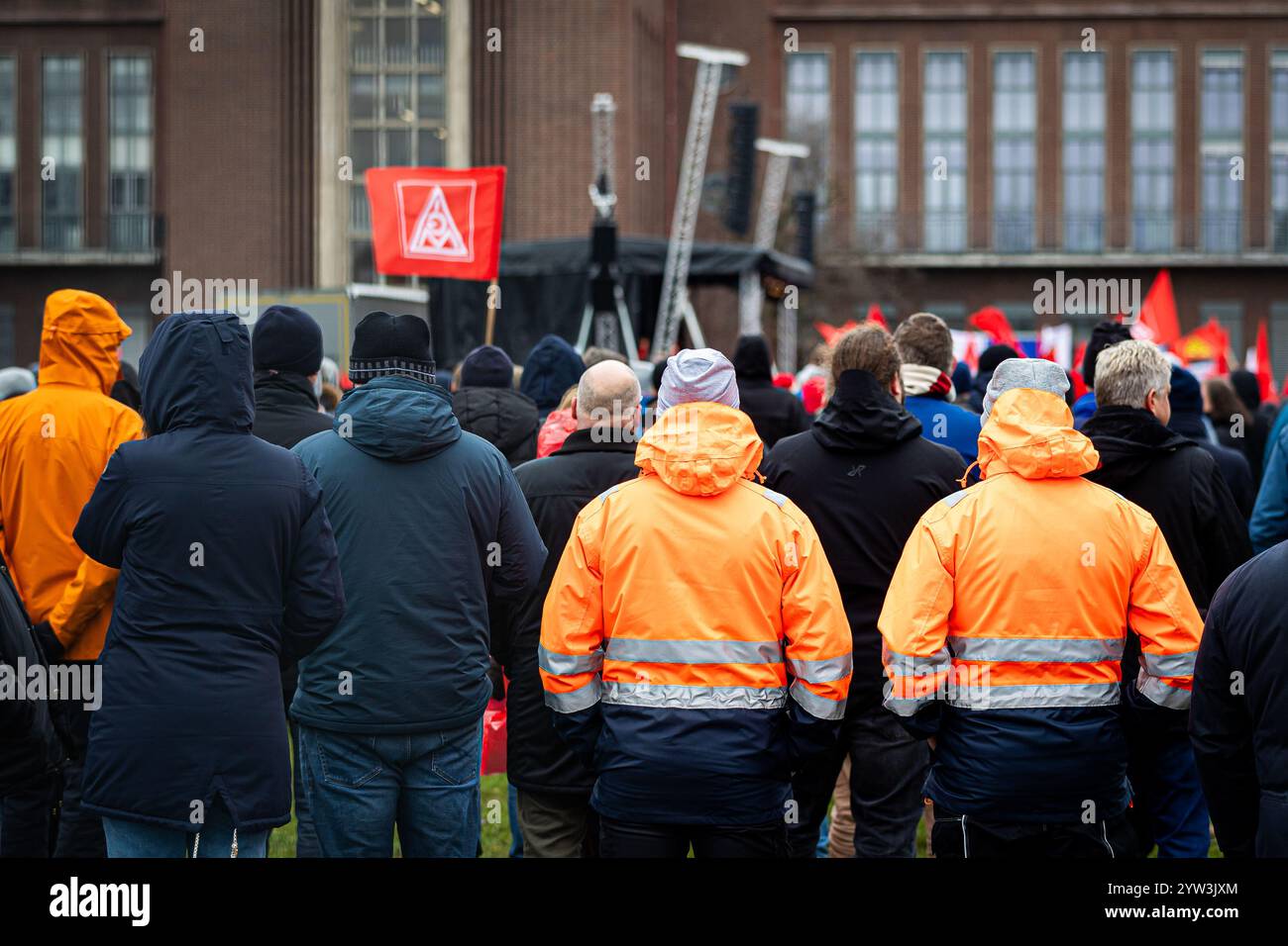 Wolfsburg, Germania. 9 dicembre 2024. I dipendenti VW partecipano a un rally IG Metall di fronte alla sede centrale della Volkswagen durante uno sciopero di avvertimento nello stabilimento principale della casa automobilistica tedesca di Wolfsburg. Crediti: Moritz Frankenberg/dpa/Alamy Live News Foto Stock