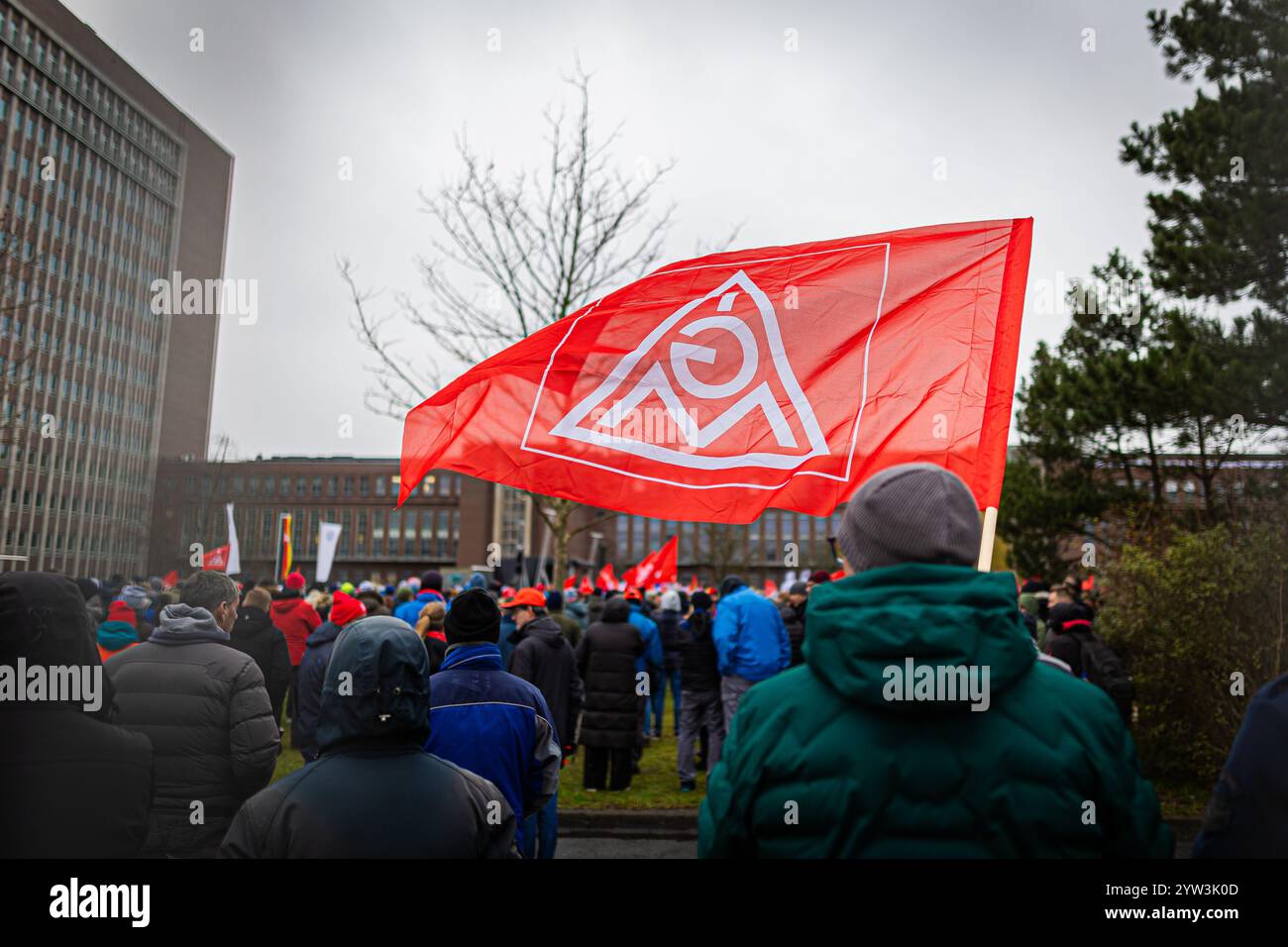 Wolfsburg, Germania. 9 dicembre 2024. I dipendenti VW partecipano a un rally IG Metall di fronte alla sede centrale della Volkswagen durante uno sciopero di avvertimento nello stabilimento principale della casa automobilistica tedesca di Wolfsburg. Crediti: Moritz Frankenberg/dpa/Alamy Live News Foto Stock