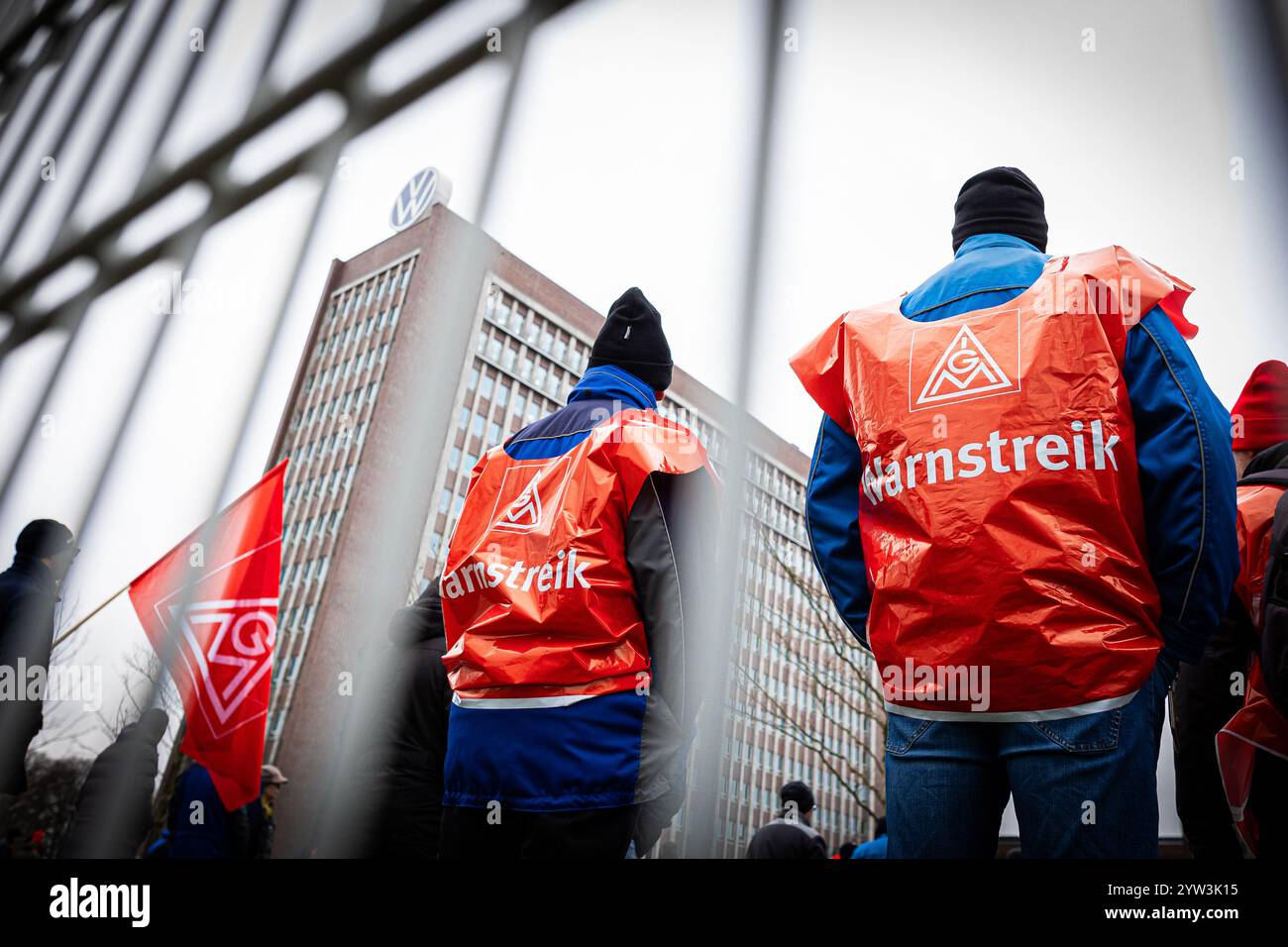 Wolfsburg, Germania. 9 dicembre 2024. I dipendenti VW partecipano a un rally IG Metall di fronte alla sede centrale della Volkswagen durante uno sciopero di avvertimento nello stabilimento principale della casa automobilistica tedesca di Wolfsburg. Crediti: Moritz Frankenberg/dpa/Alamy Live News Foto Stock