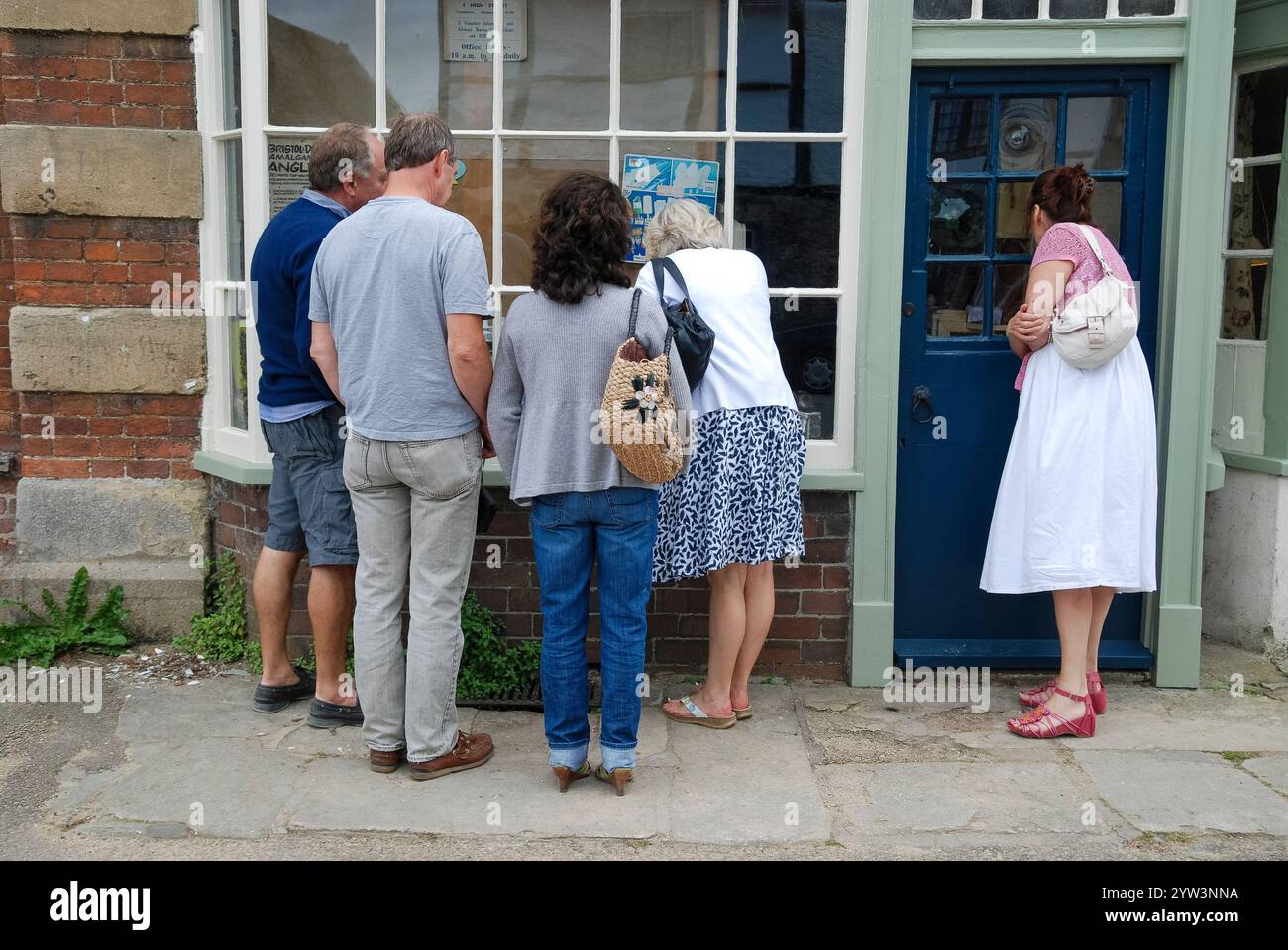 Persone che guardano in una vetrina vuota Foto Stock