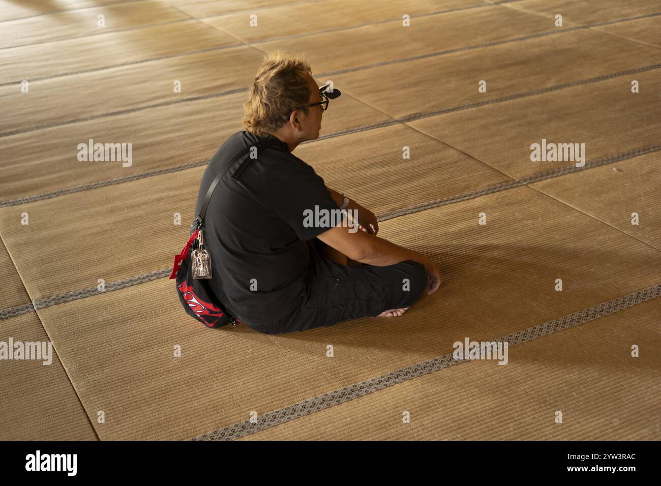 Turista con occhiali che meditano sul tatami, Higashi Hongan-ji, Kyoto, Giappone, Asia Foto Stock