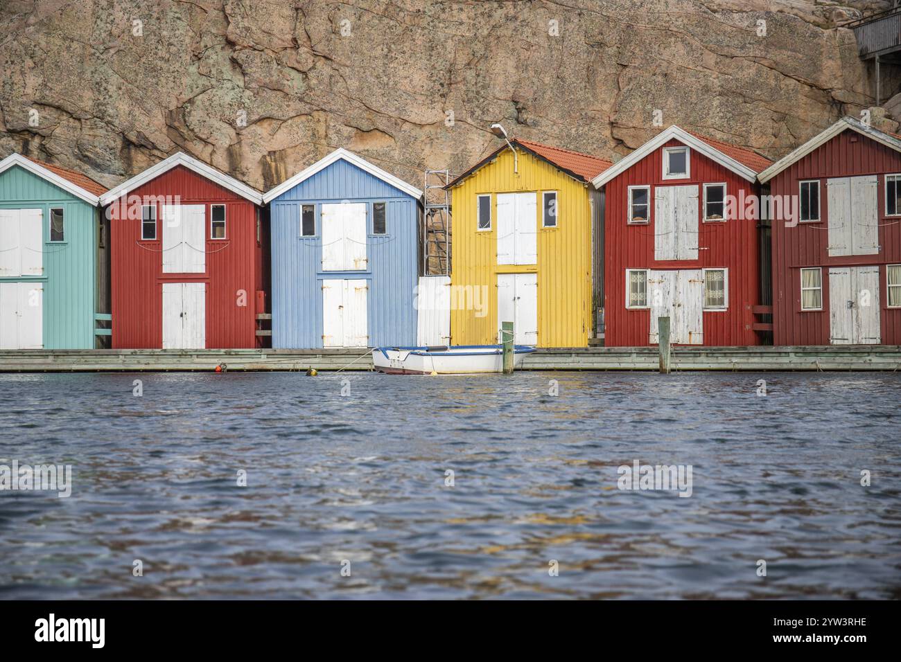 Piccole case colorate sul mare. Case tipiche in Svezia per il paesaggio costiero. Pesca dei granchi e stoccaggio in un porto stretto. Smoegen, Smoegenb Foto Stock